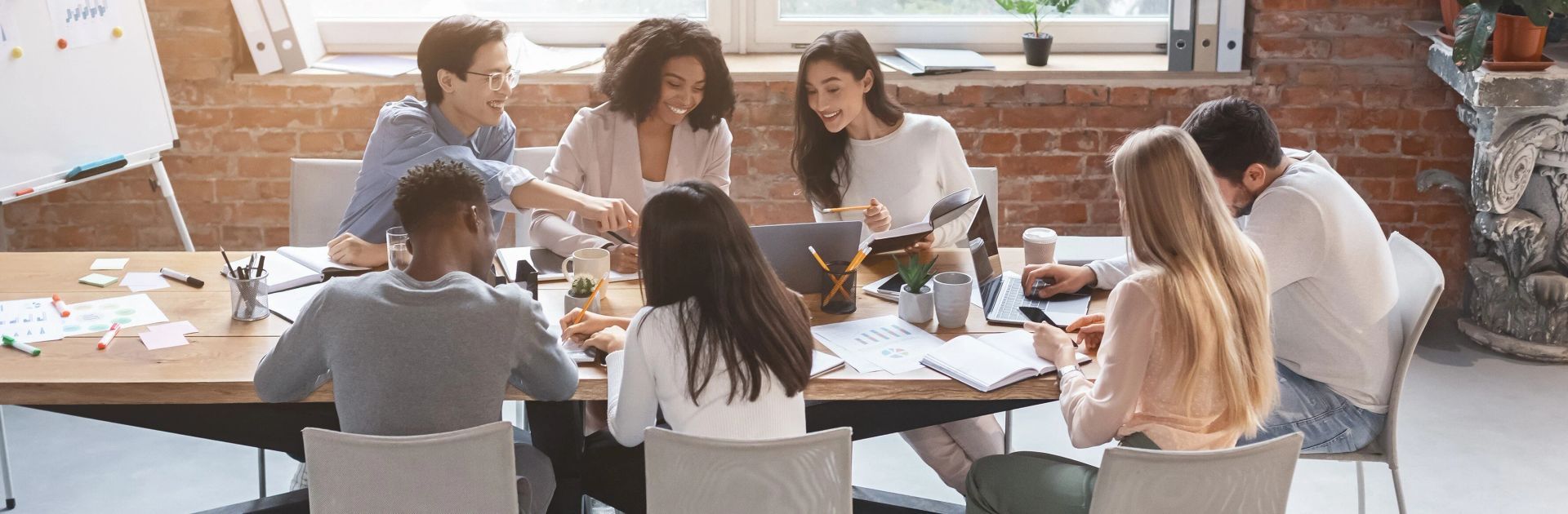 A group of people are sitting around a table having a meeting.