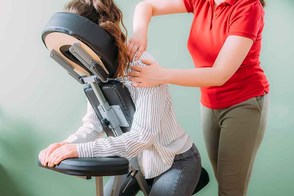 A woman is getting a massage in a chair.