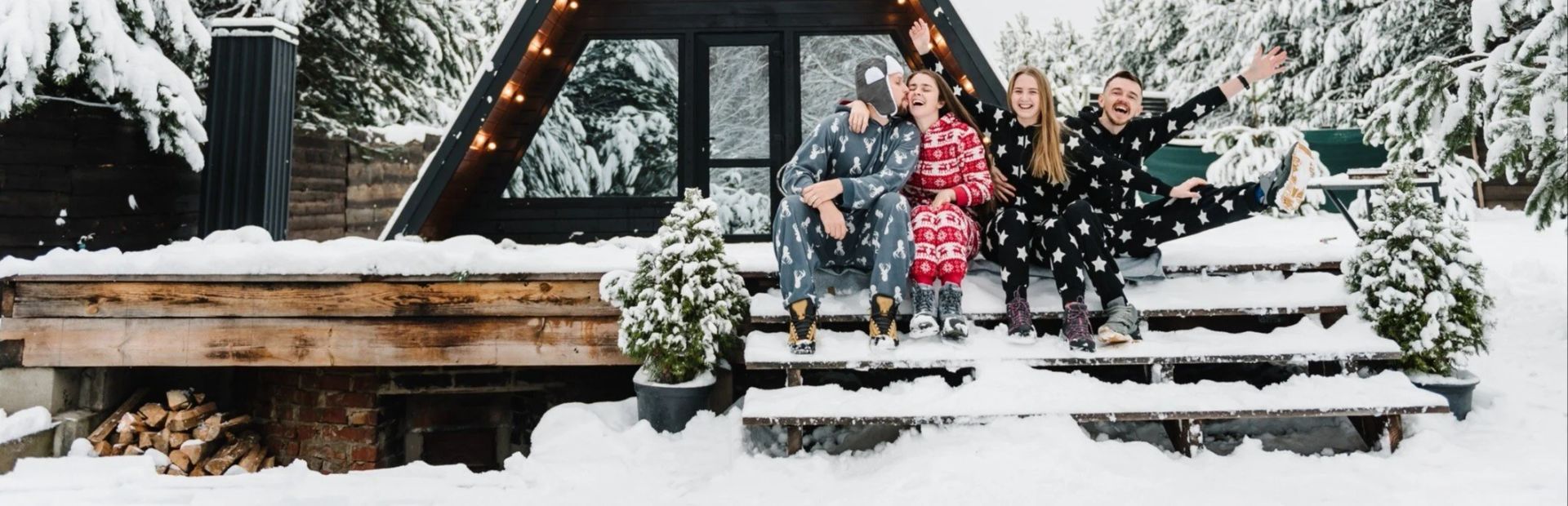 A group of people are standing in front of a cabin in the snow.