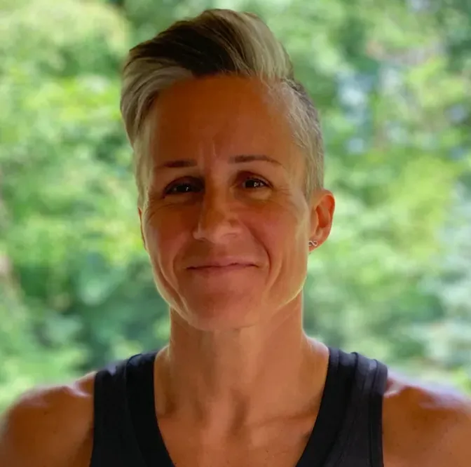 A close up of a woman 's face with trees in the background.