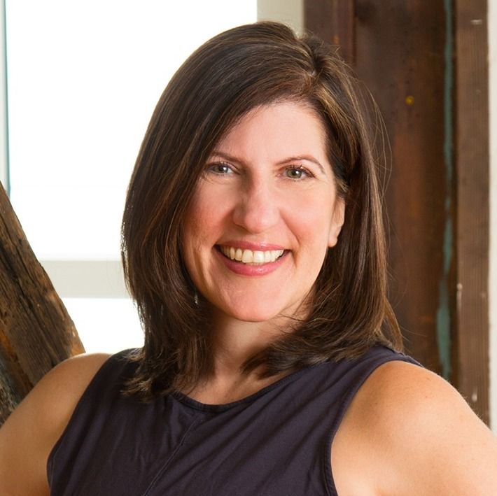 A woman in a black tank top smiles for the camera