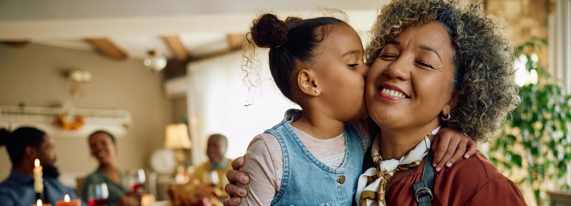 A little girl is kissing her grandmother on the cheek.