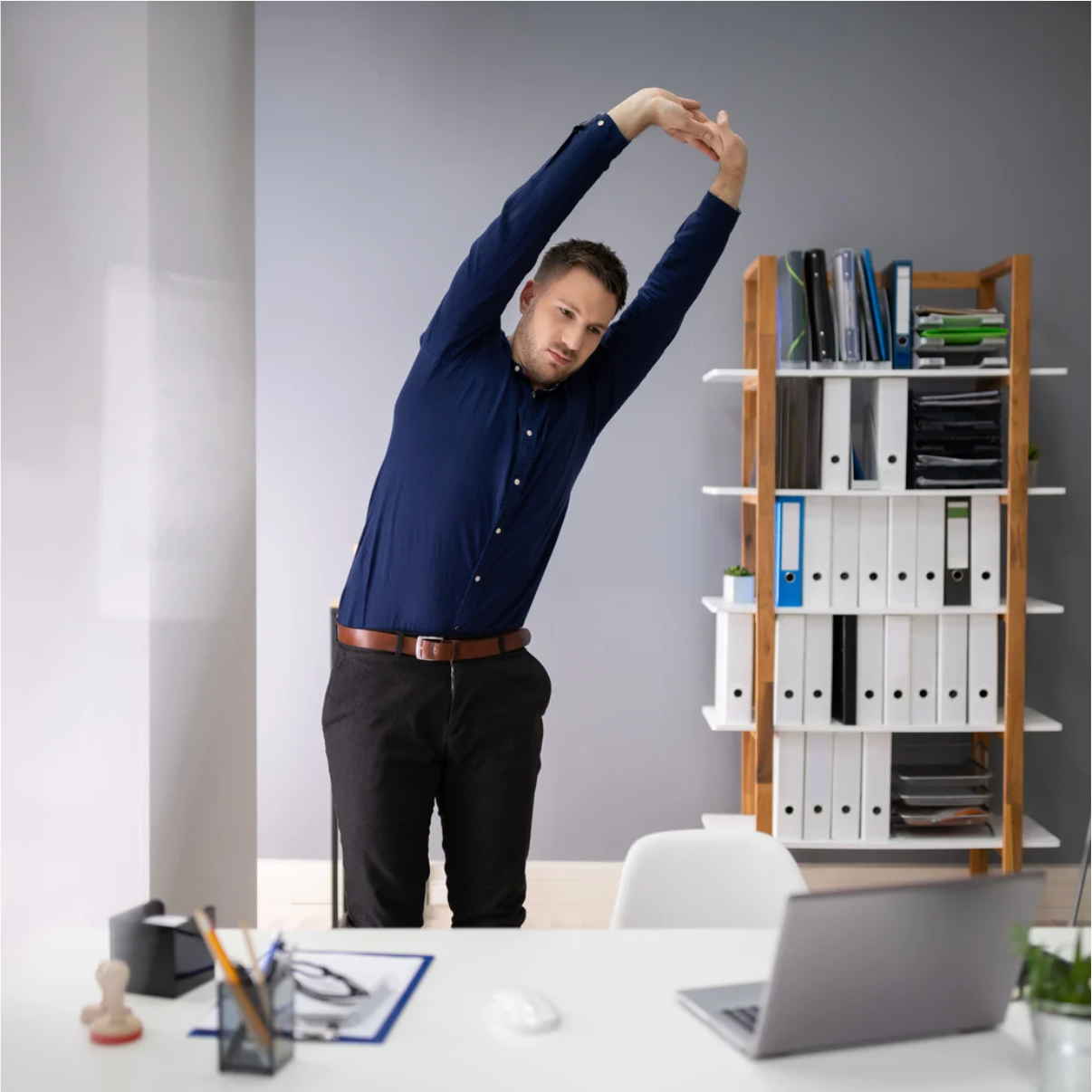A bottle of essential oil is sitting next to a bowl of dried flowers.
