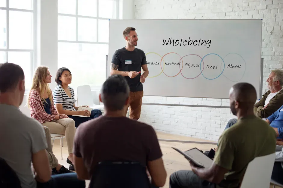 A man is giving a presentation to a group of people sitting in a circle.