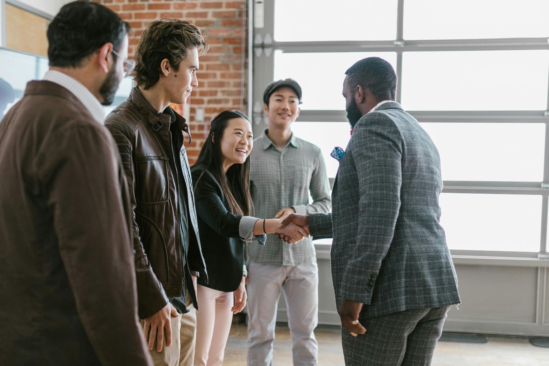 A group of people are shaking hands in a room.