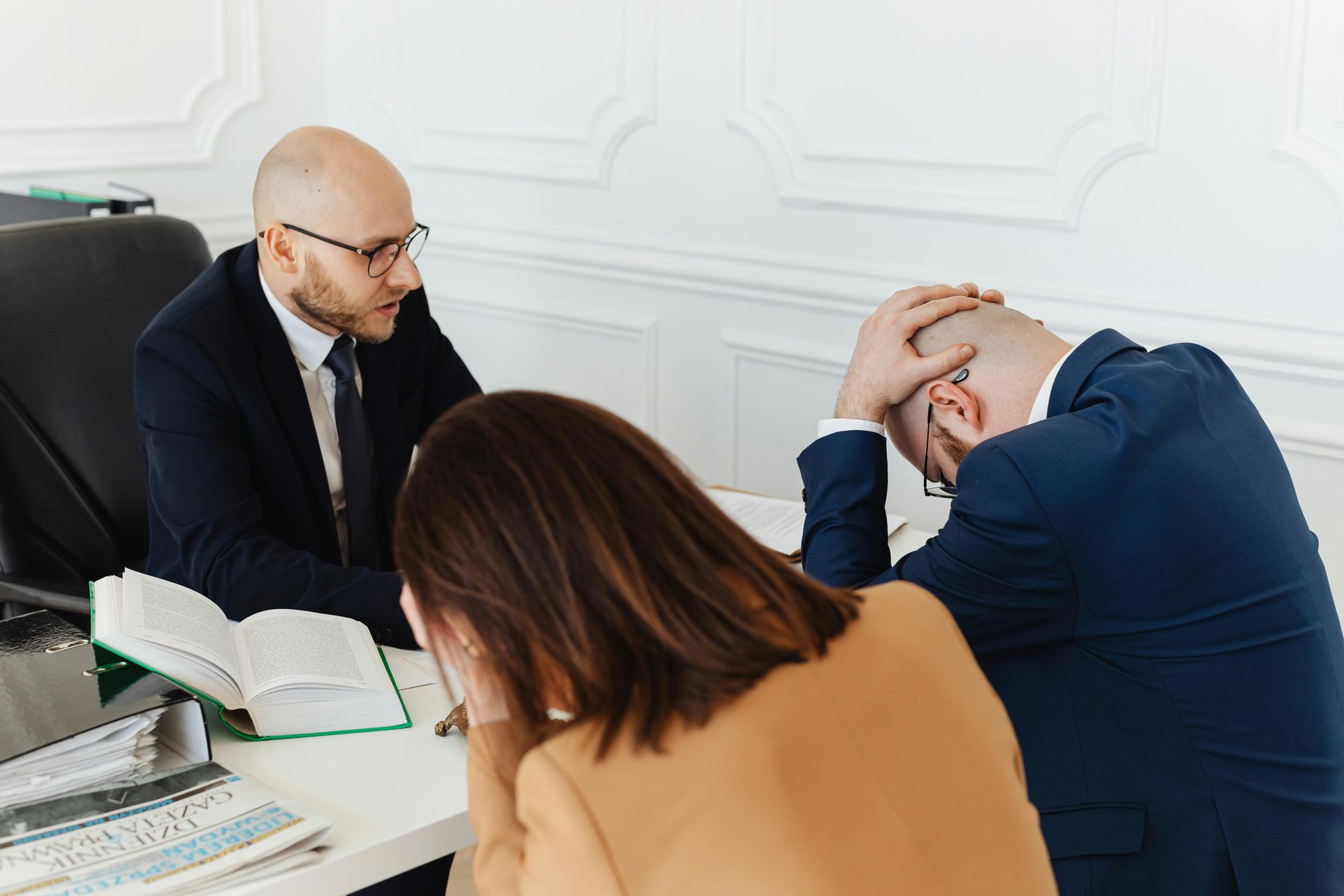 A man and a woman are sitting at a table talking to a lawyer.