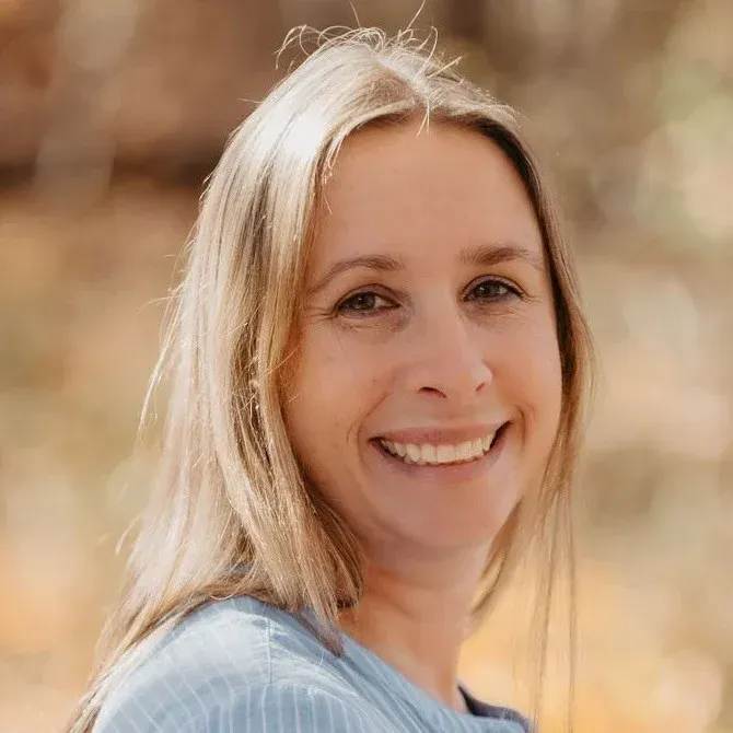 A woman with long blonde hair is smiling for the camera.