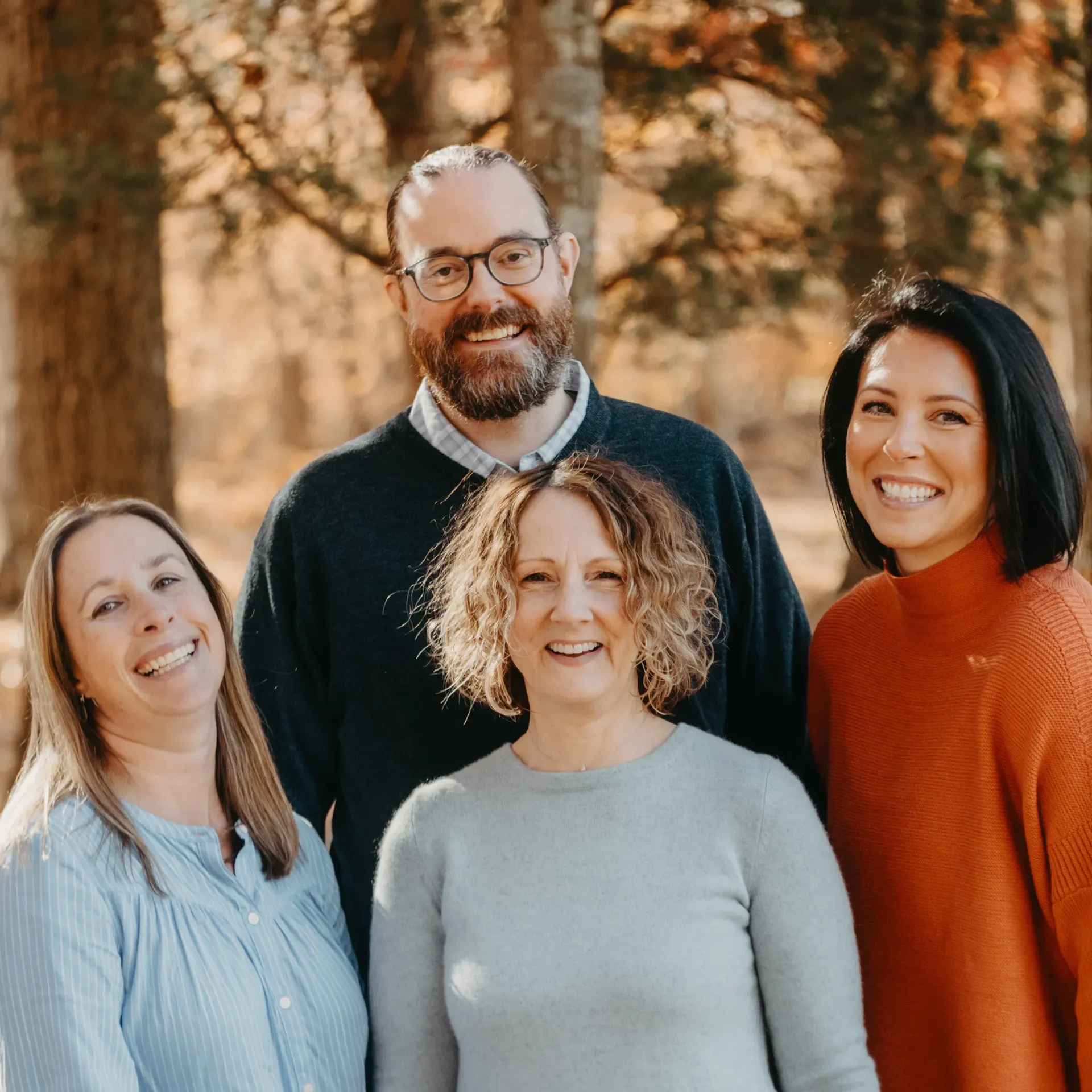 A group of people are posing for a picture together and smiling.