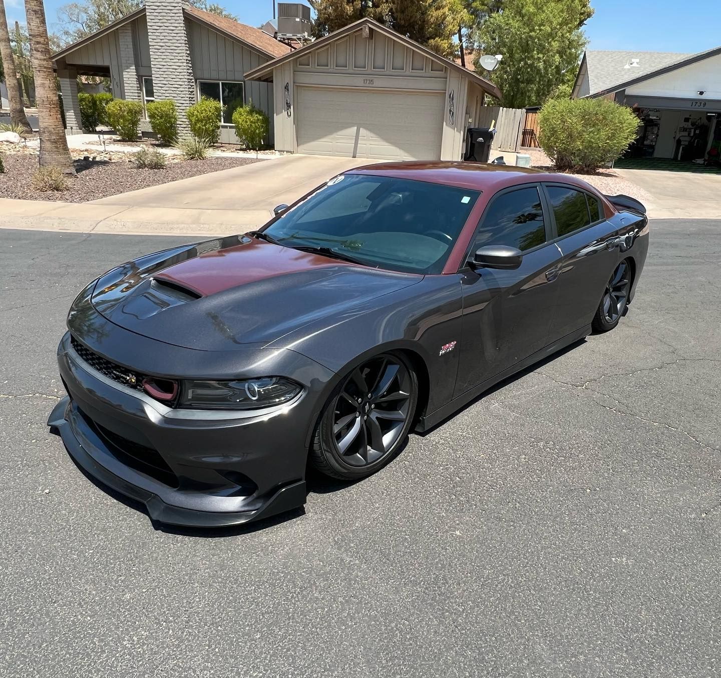 Gray Dodge Charger with a red hood and roof in a residential driveway.