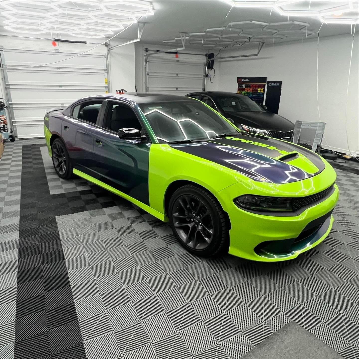 Lime green and dark purple Dodge Charger in a garage.