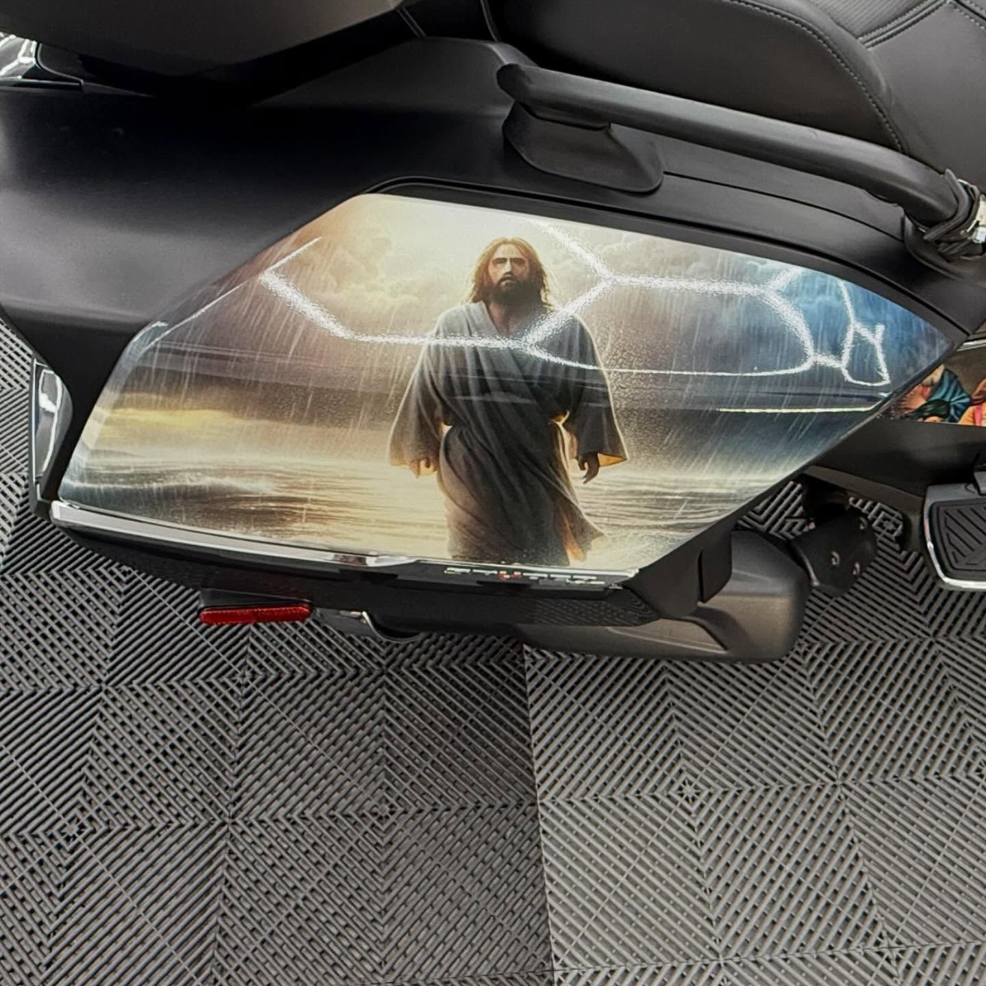 A motorcycle side panel displaying Jesus walking on water with lightning and a stormy sky.