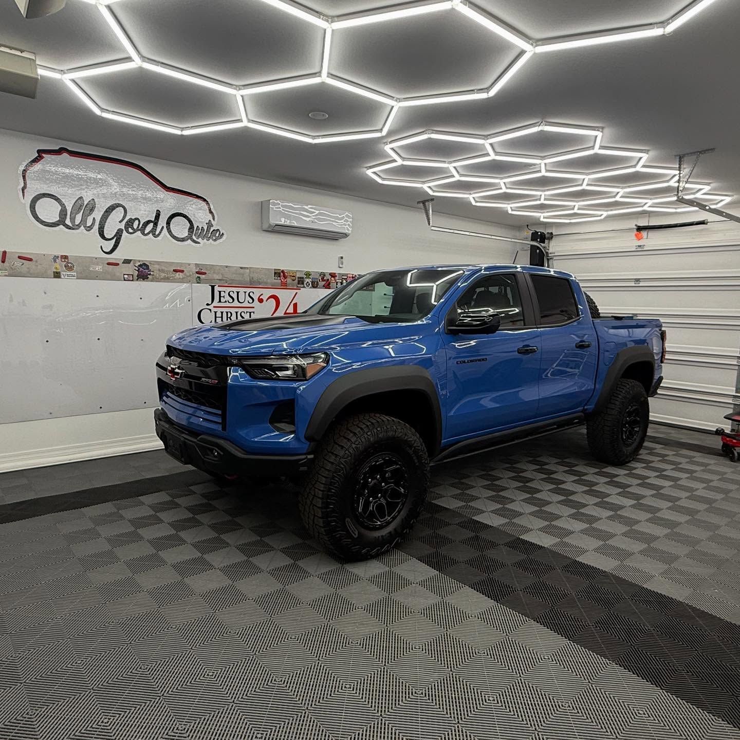 Blue truck inside a garage with hexagon lights and 