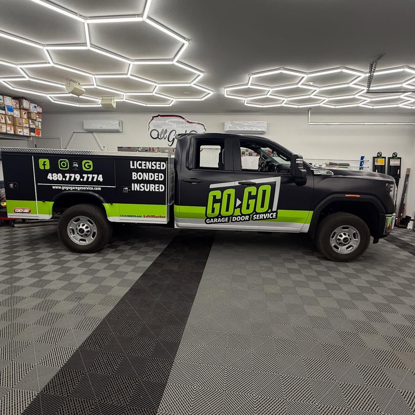 Black and green work truck in garage with hexagon lights; 