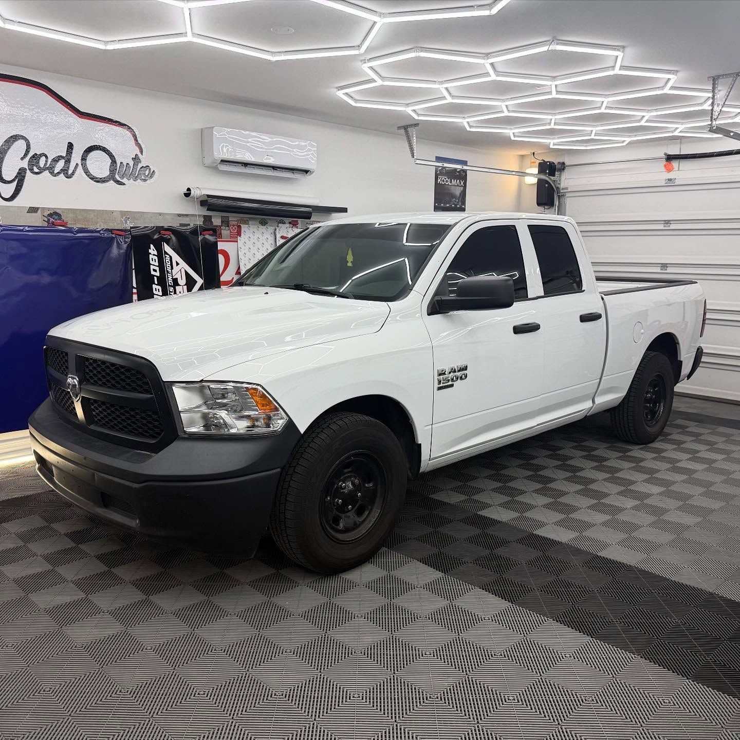 White Dodge Ram pickup truck in a garage with hexagon lights.
