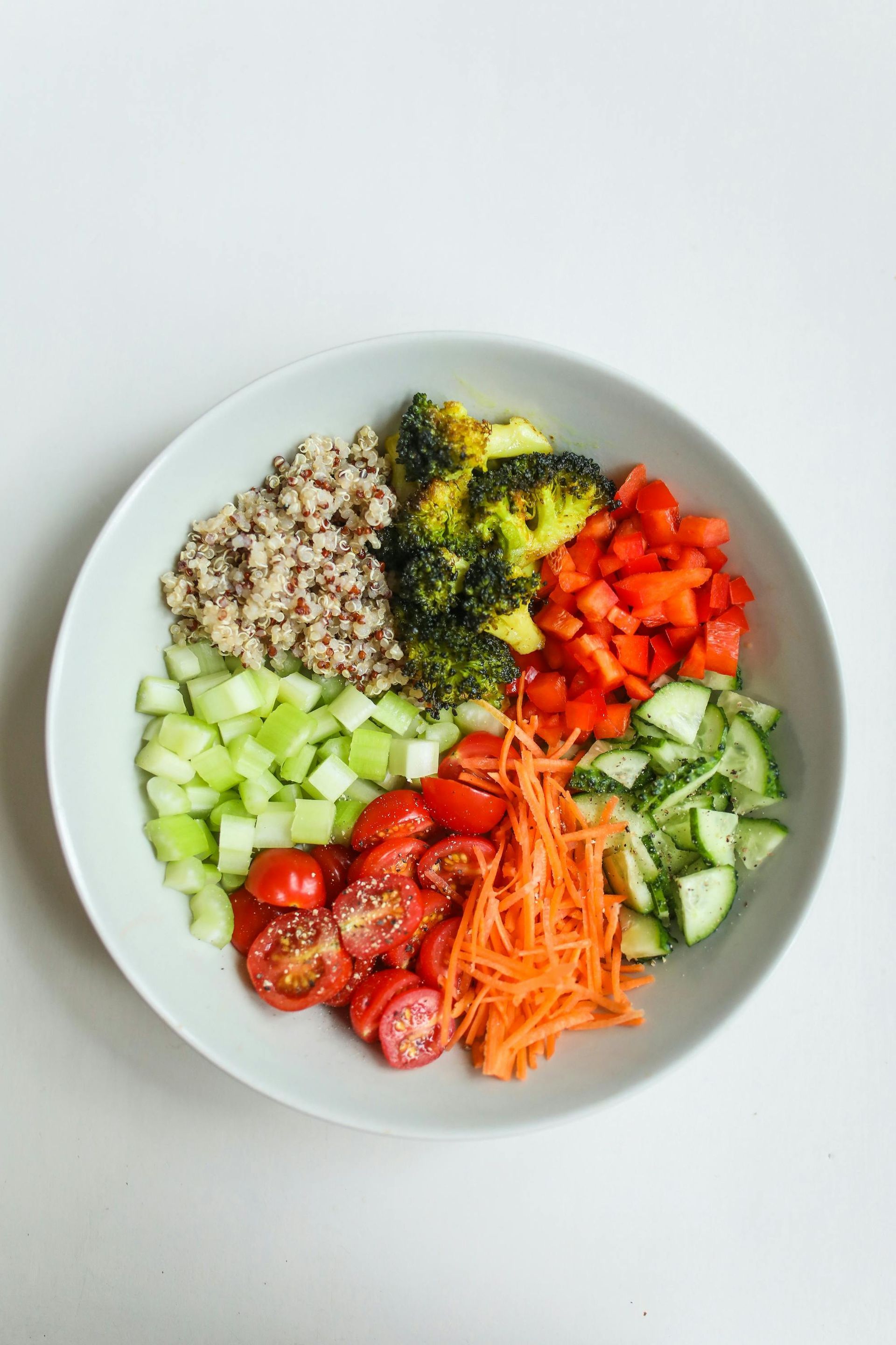 A bowl filled with vegetables and rice on a table.
