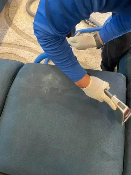 A man is cleaning the interior of a car with a vacuum cleaner.