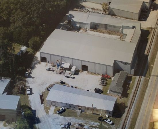 An aerial view of a warehouse with cars parked in front of it