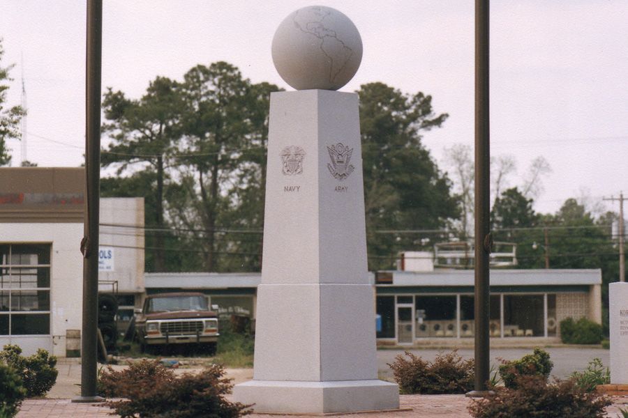 A statue with a globe on top of it that says ' united states of america ' on it
