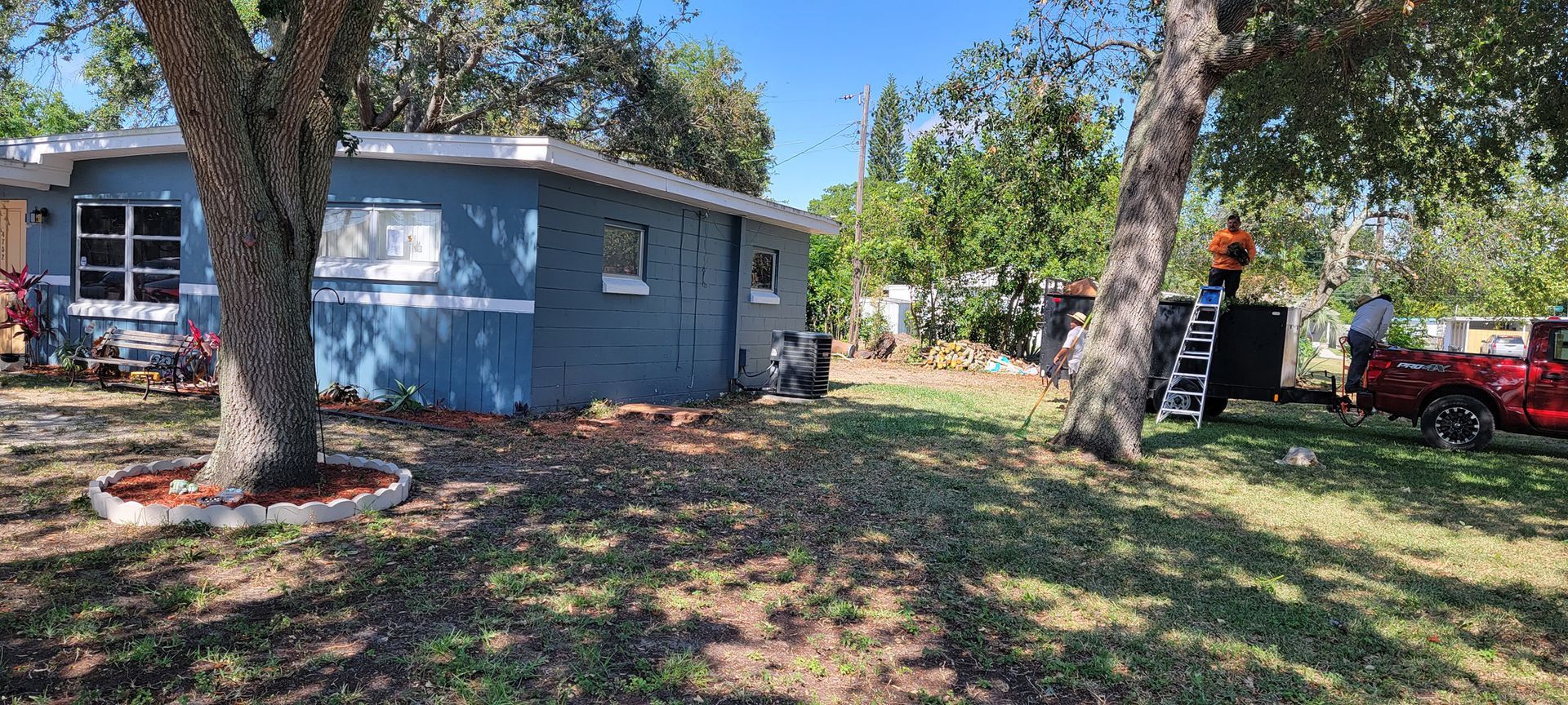 A blue house with a red truck parked in front of it.