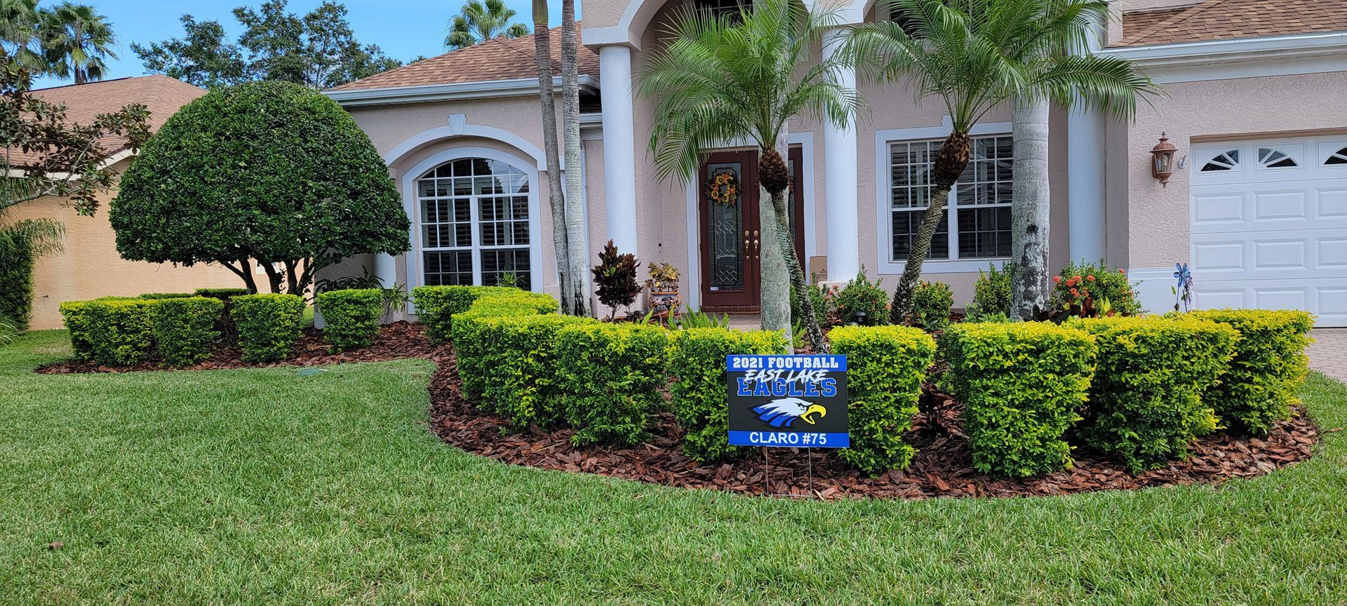 A house with a blue sign in front of it.
