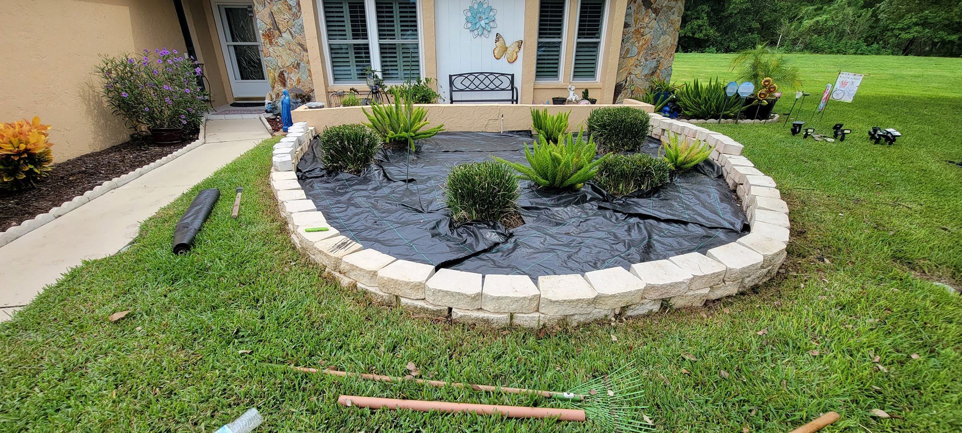 A house with a circular garden in front of it.
