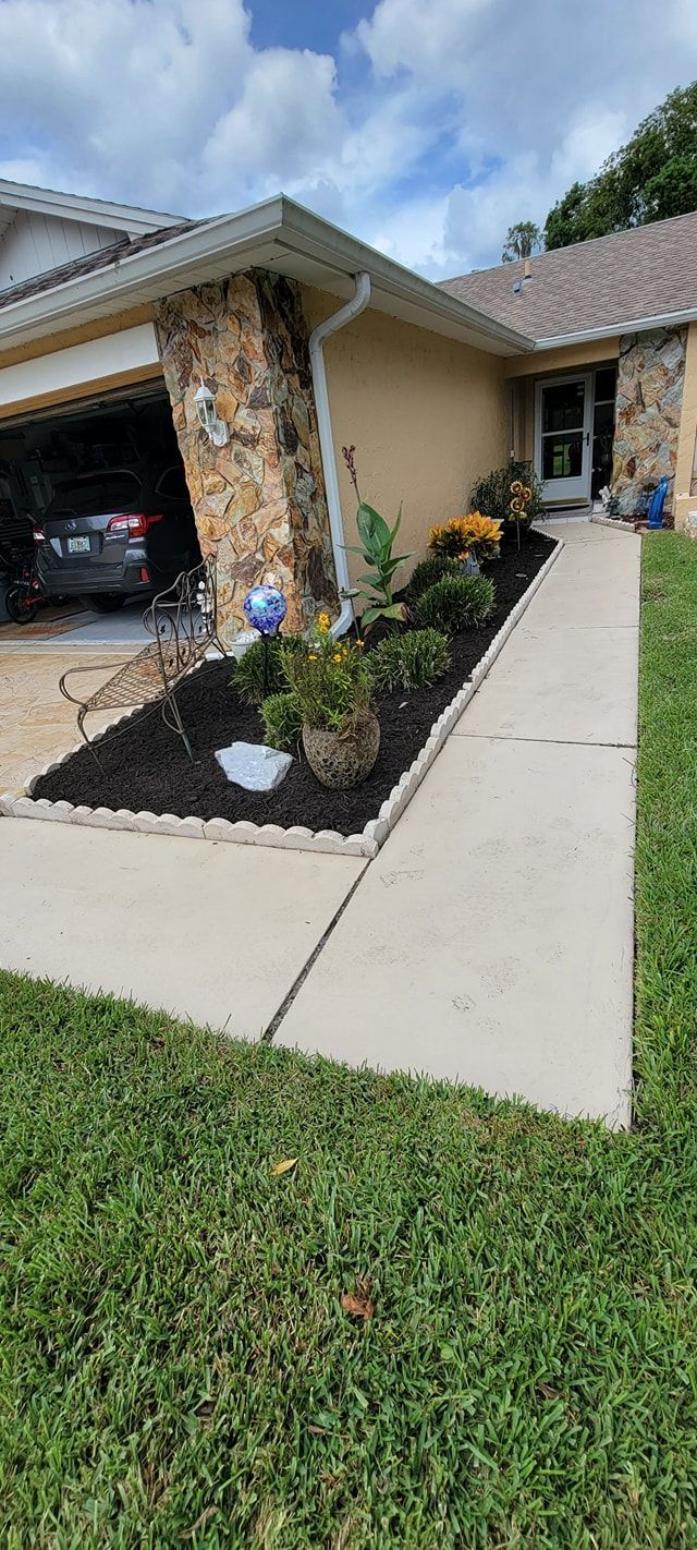 A house with a walkway leading to it and a car parked in the driveway.