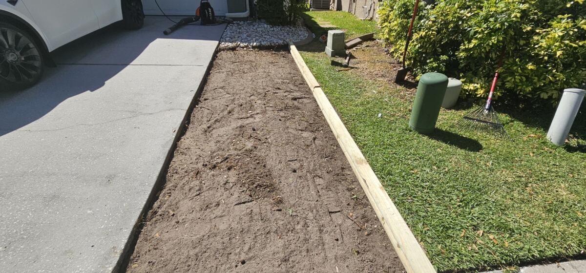 A car is parked on the side of the road next to a dirt path.
