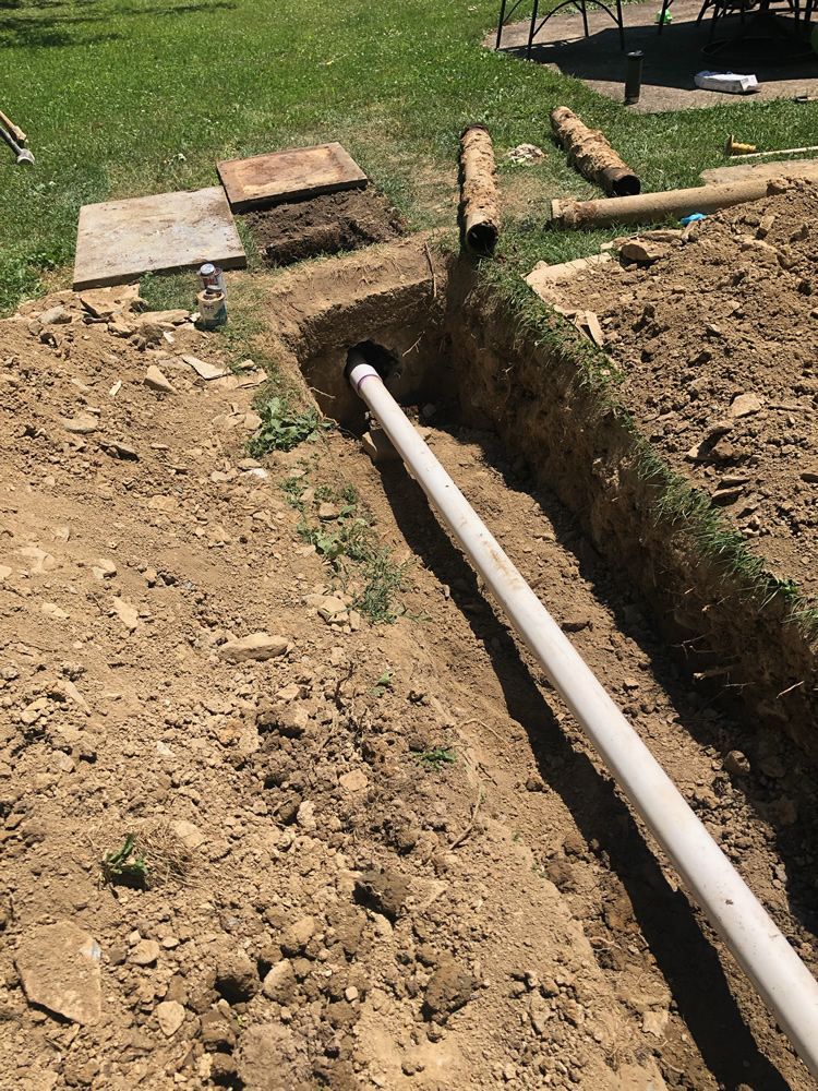 A pipe is being installed in a hole in the ground.