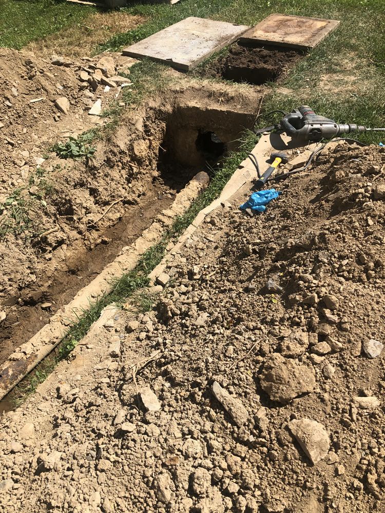 A pipe is being installed in the dirt in a backyard.