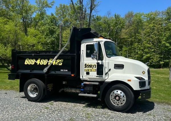 A dump truck is parked on a gravel road
