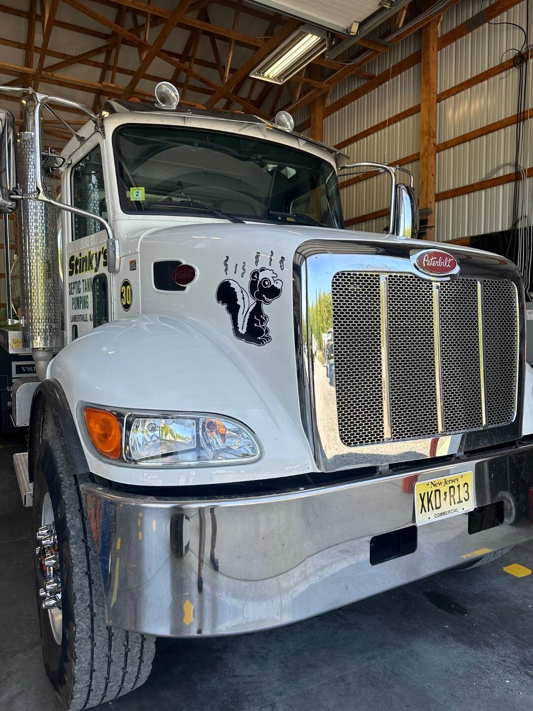 A white semi truck is parked in a garage.