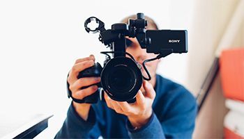 A man is taking a picture with a video camera.