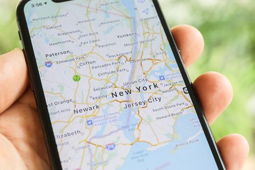 a person is holding a cell phone with a map of new york on it .