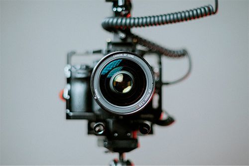 A close up of a camera on a tripod with a microphone attached to it.