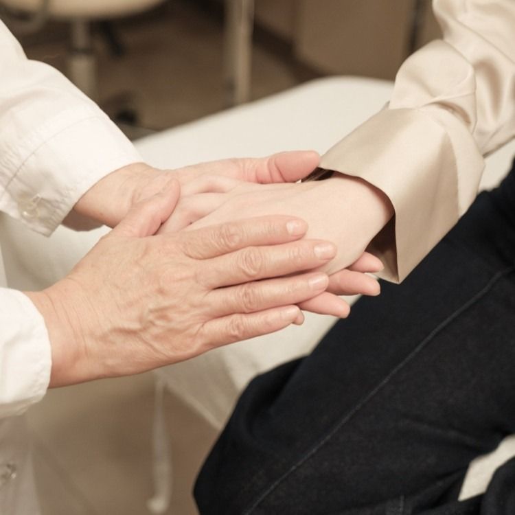 Doctor holding patient's hands for support.