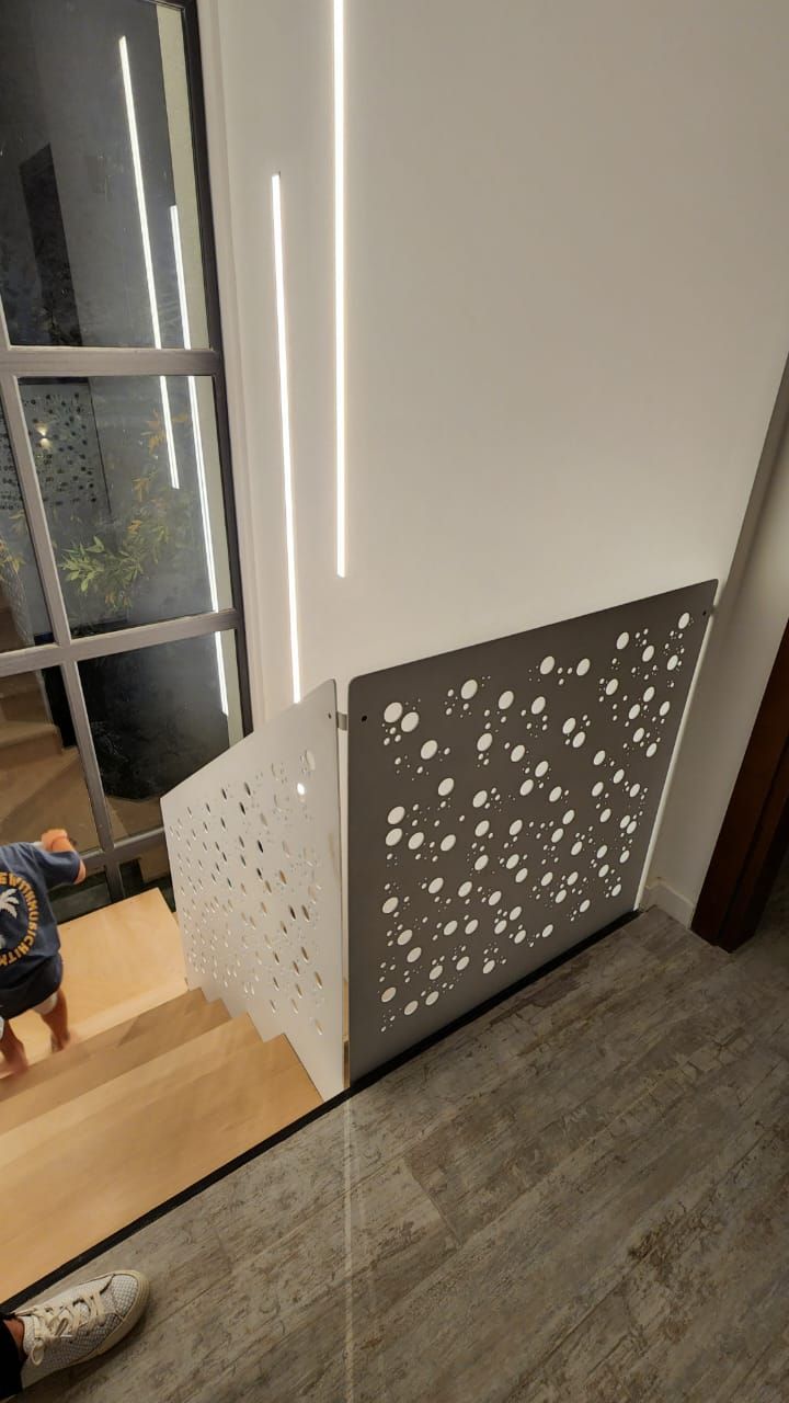 Una persona está parada junto a una escalera de madera con una barandilla de metal.