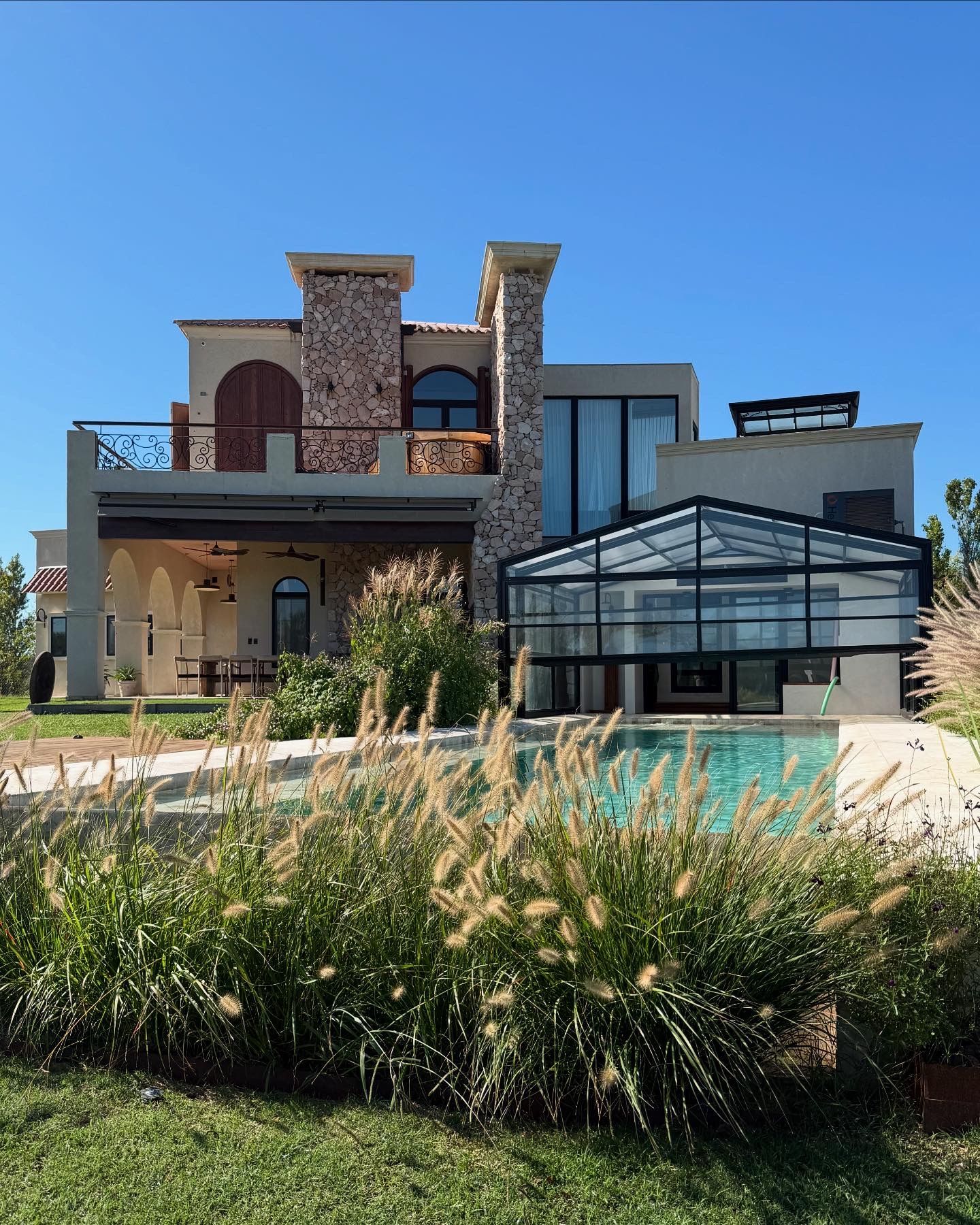 Una casa grande con piscina delante de ella.