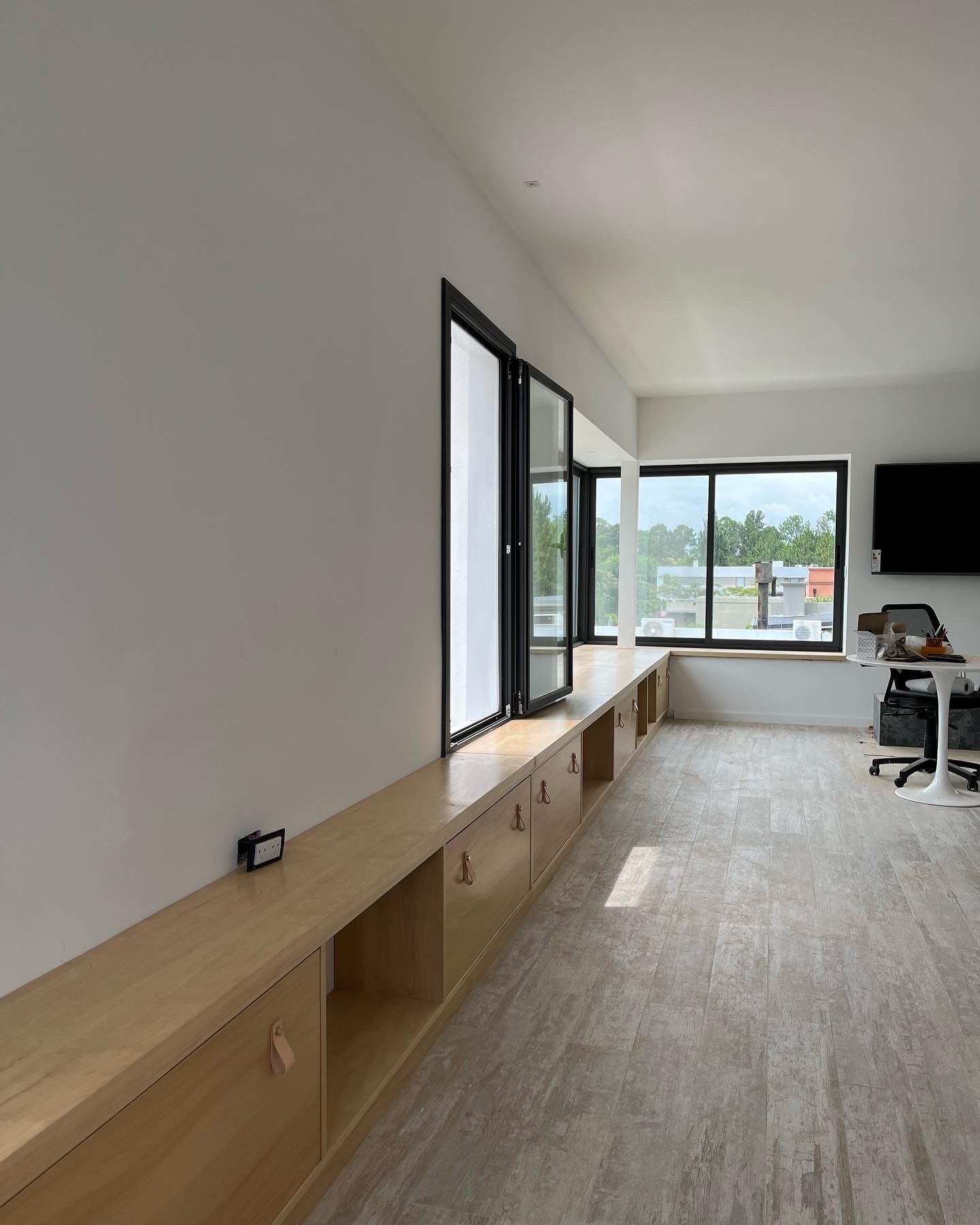 Una habitación con muchas ventanas y un escritorio.