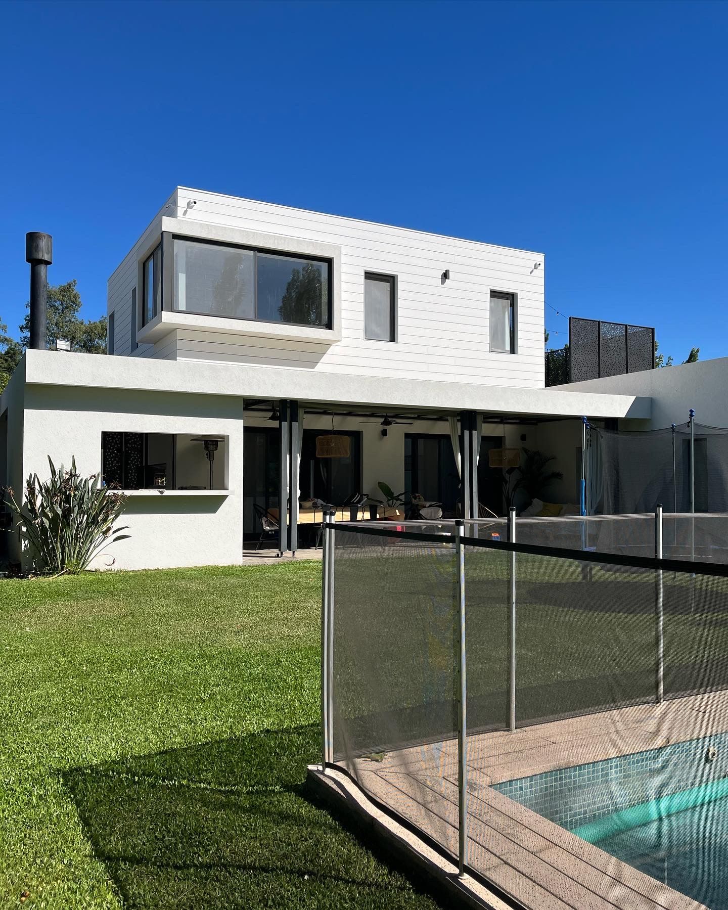 Una gran casa blanca con una piscina delante de ella.