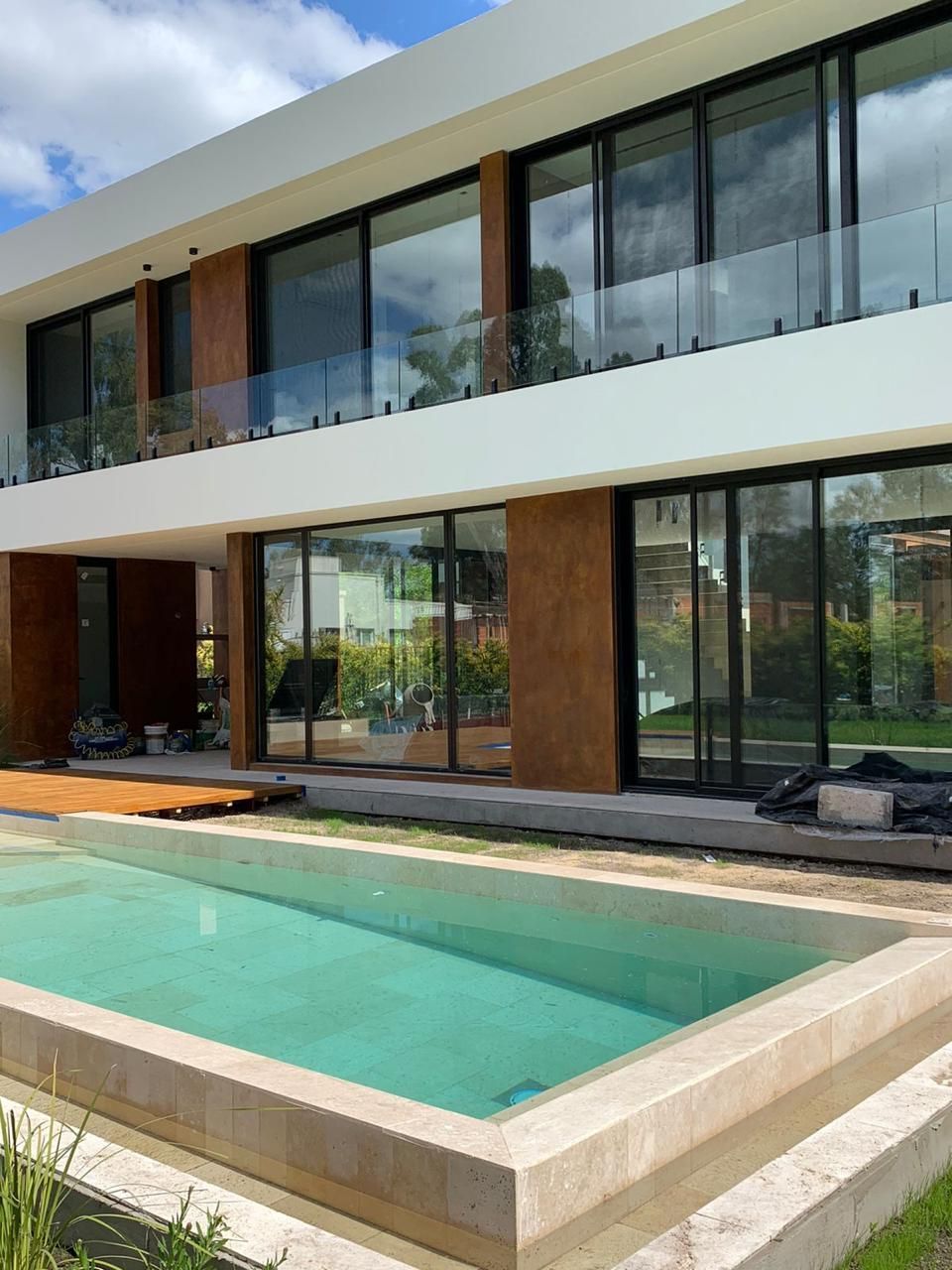 Una casa grande con piscina delante de ella.