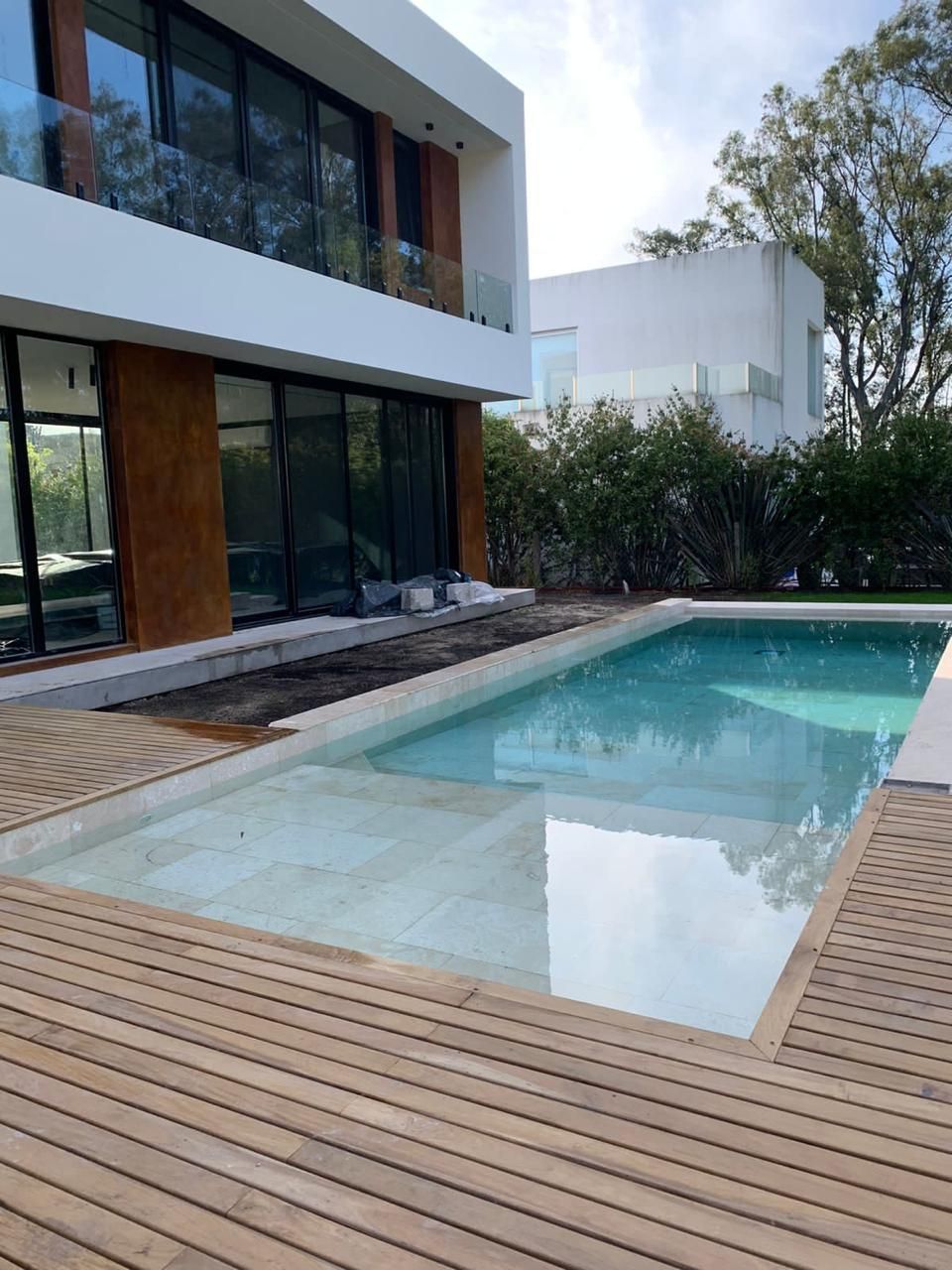 Una casa grande con una gran piscina en frente de ella.
