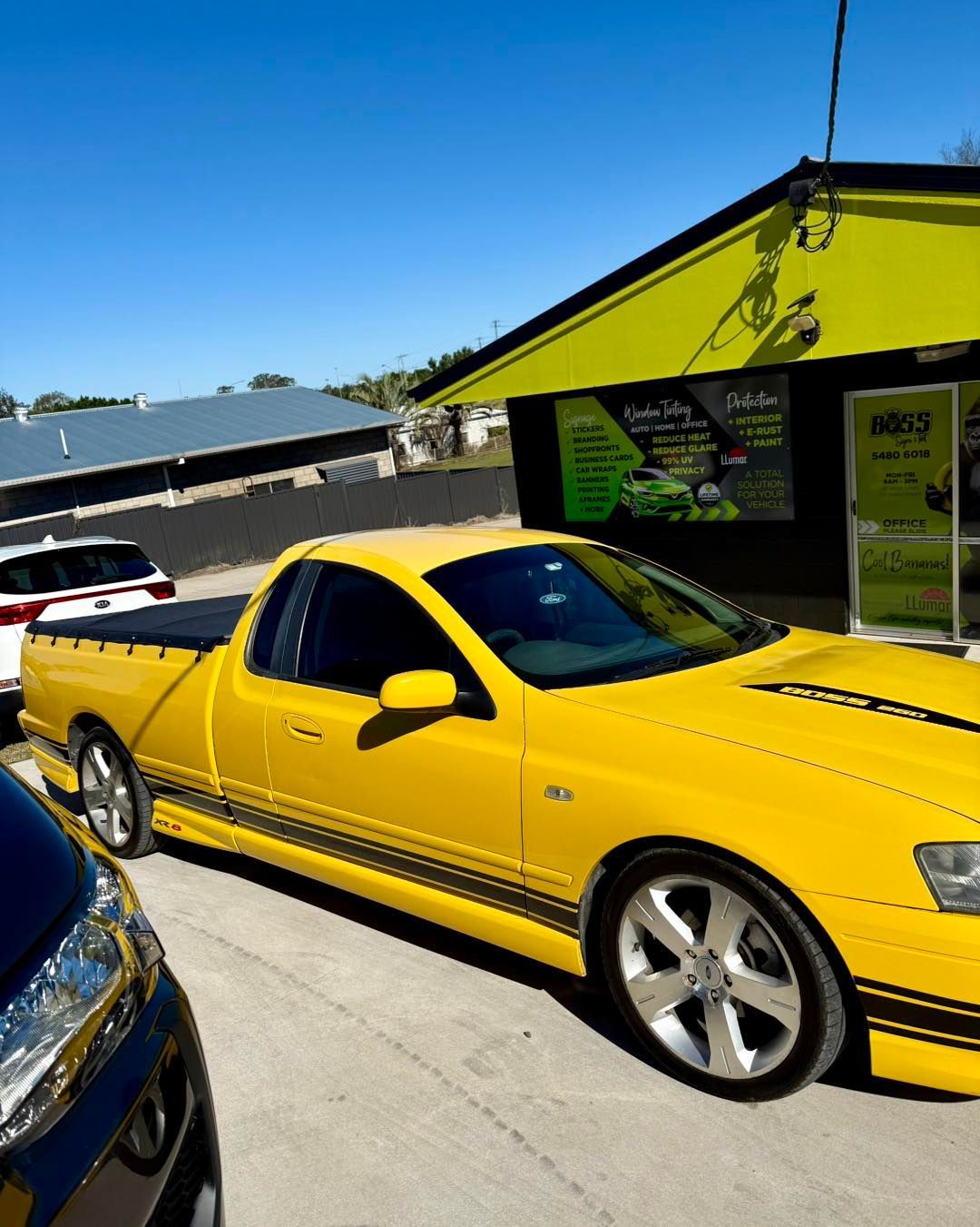Yellow Utility Vehicle Parked Outside a Bright Green Business — Boss Signs & Tint in Gympie, QLD