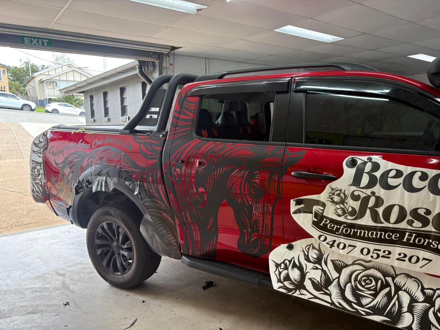 Red pickup truck with black floral wrap; 