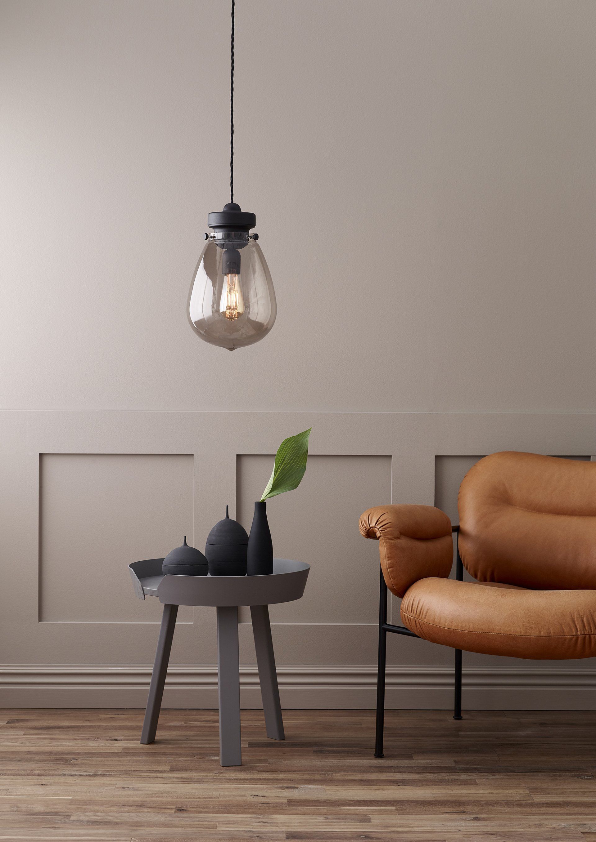 brūns dīvāns ar lampu un pelēku galdiņu