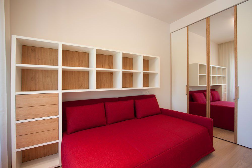 gaiša guļamistaba ar sarkanu gultu