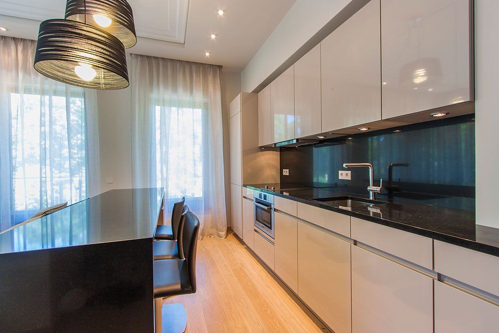 Virtuve ar baltu virtuves tehniku un melnu galdu