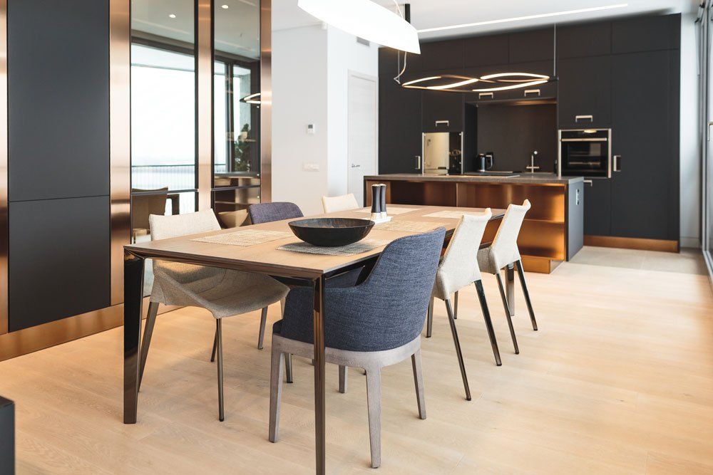moderni iekārtota virtuve ar krēsliem un koka galdu