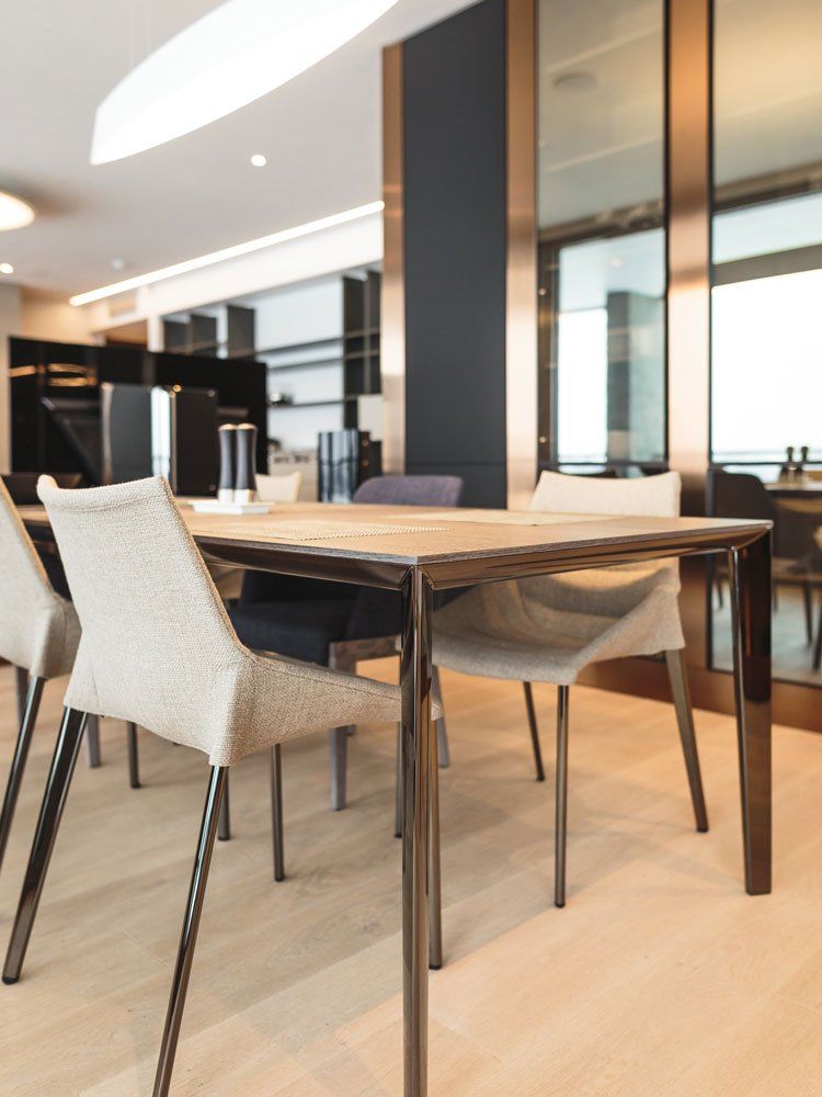 gaiša telpa ar baltiem krēsliem un koka galdu