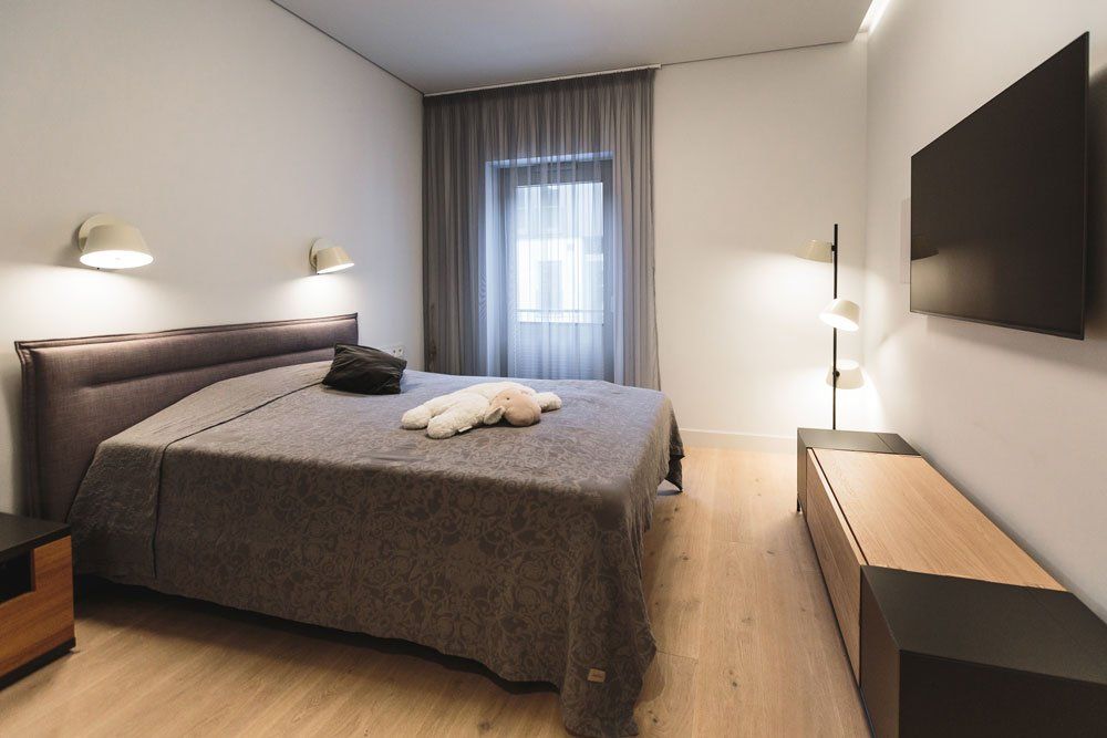 guļamistaba ar divvietīgo gultu, stāvlampu un skapīti