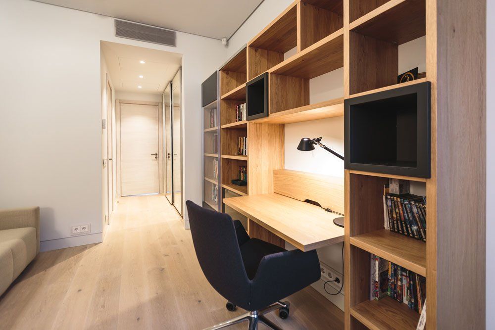 darba istaba ar biroja krēslu un grāmatu plauktu